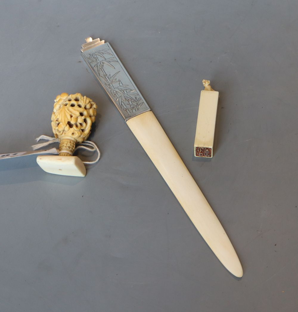 An ivory carving, an ivory seal and an ivory page turner, the handle marked sterling silver, all late 19th or early 20th century,